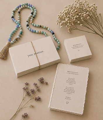 Breathe Love cards, beads, and delicate flowers arranged in warm natural light.
