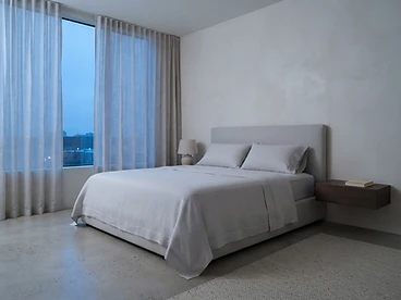 A pristine bedroom with perfectly made linen sheets