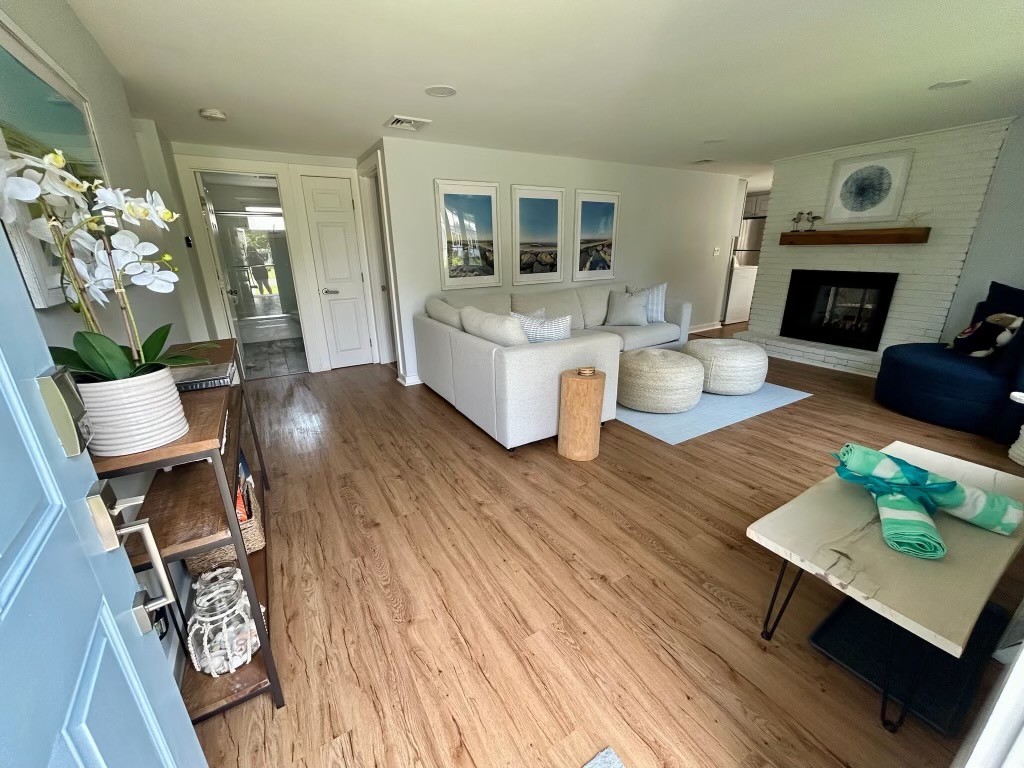 Cozy living room area in a Cape Cod rental with sectional sofa and fireplace