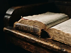 A worn open Bible on a wooden pulpit