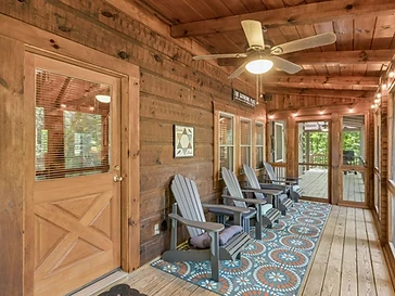Covered porch with Adirondack chairs and string lights