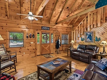Living area with vaulted ceiling and staircase