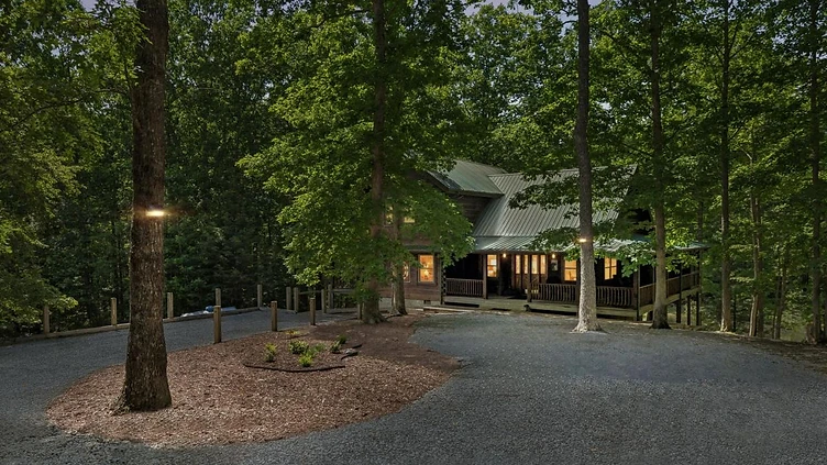Log cabin glowing at twilight among the trees