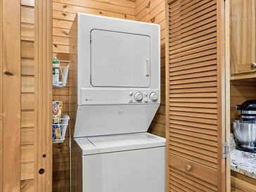 Stacked laundry unit in a wooden closet