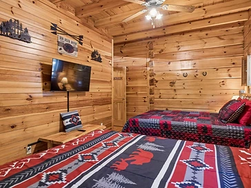 Bedroom with two beds, mounted TV, and rustic decor