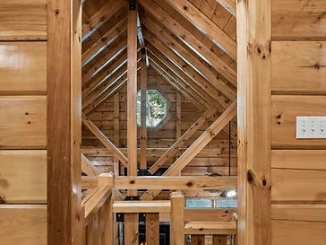 Wooden archway framing a staircase to the lower level