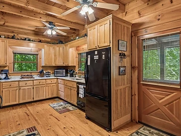 Kitchen with white appliances and forest view