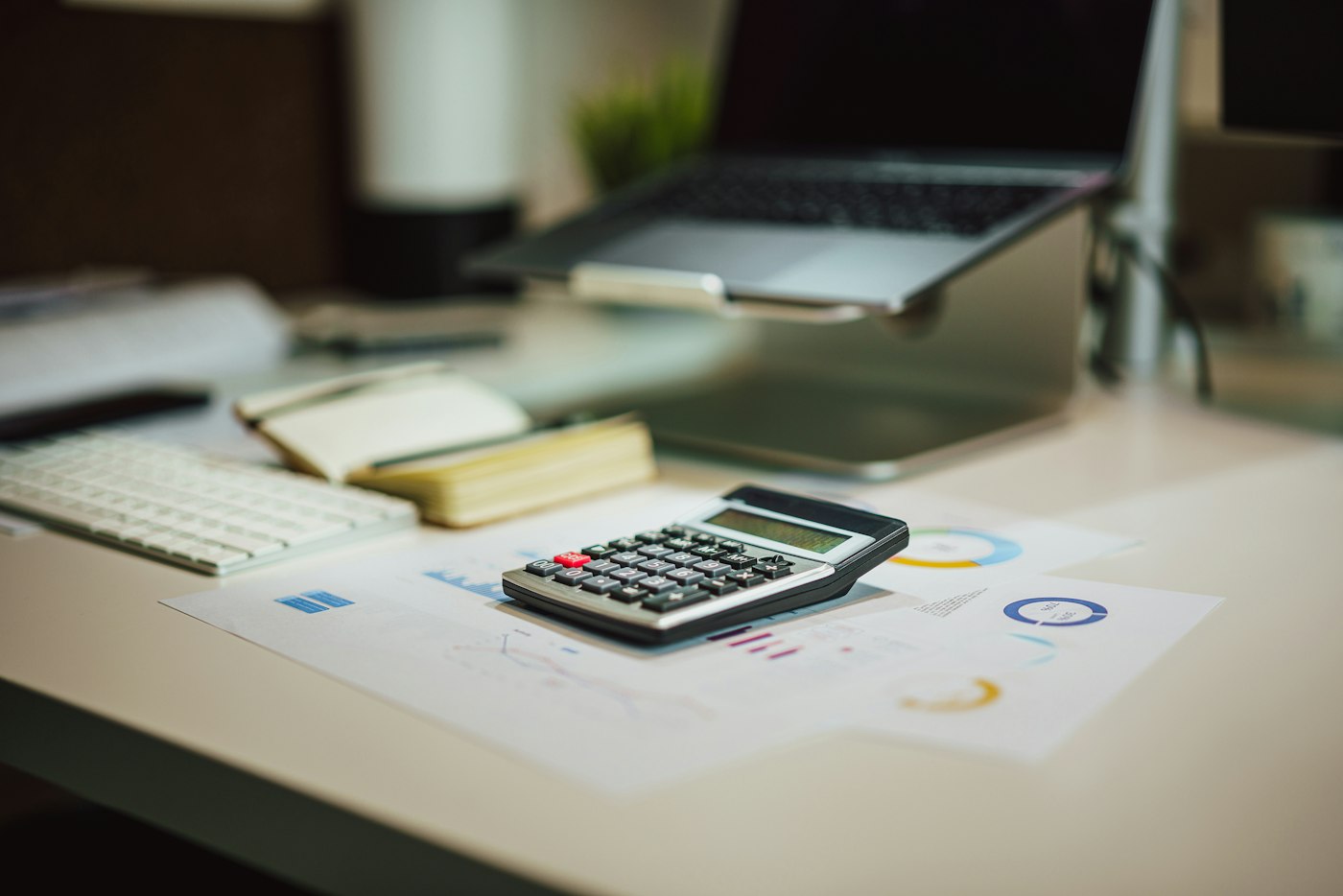 Calculator and laptop on a desk, mid close