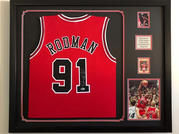 A signed Dennis Rodman Chicago Bulls jersey preserved in a shadow box with action photographs, a commemorative plaque and a trading card