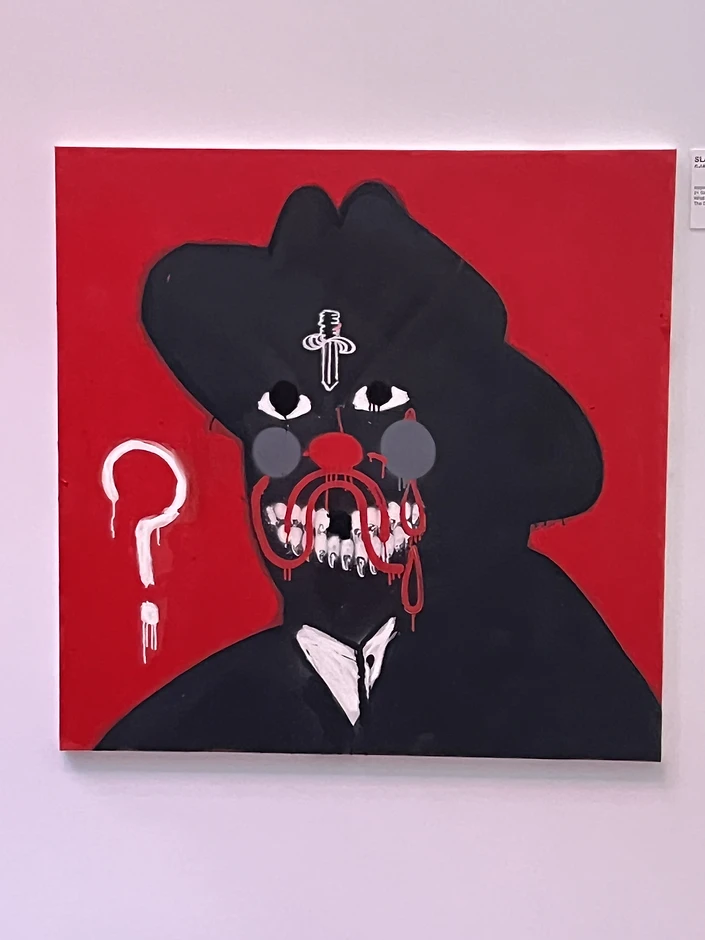 A custom-framed square canvas painting of a stylized clown figure on a vibrant red background, artwork courtesy of Epic Records