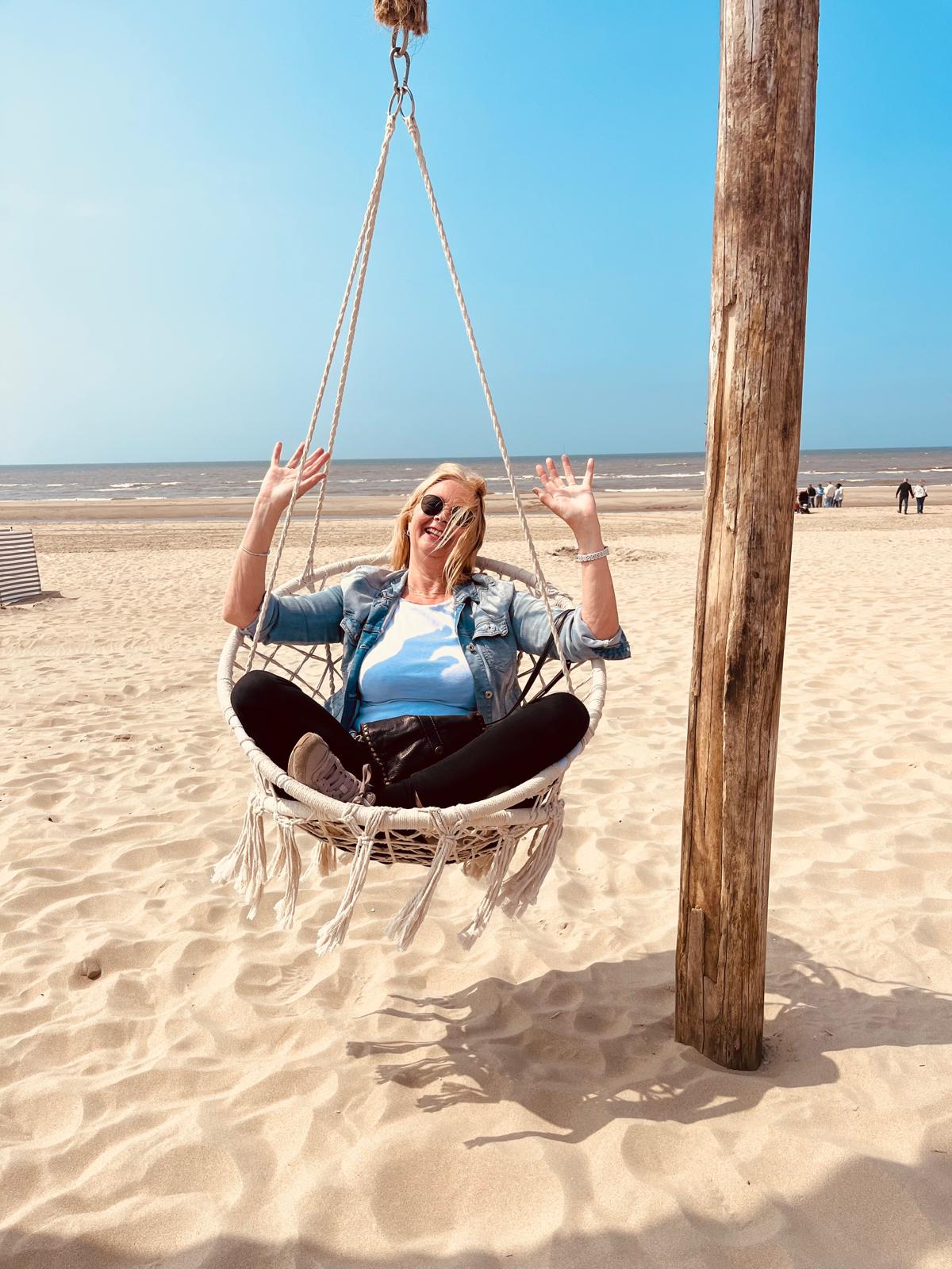 Jacqueline ontspannen in een hangstoel op het strand