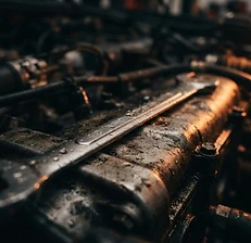 Wrench resting on an engine block under orange light