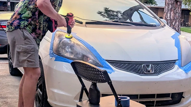 Thor restoring a headlight on-site with a rotary polisher