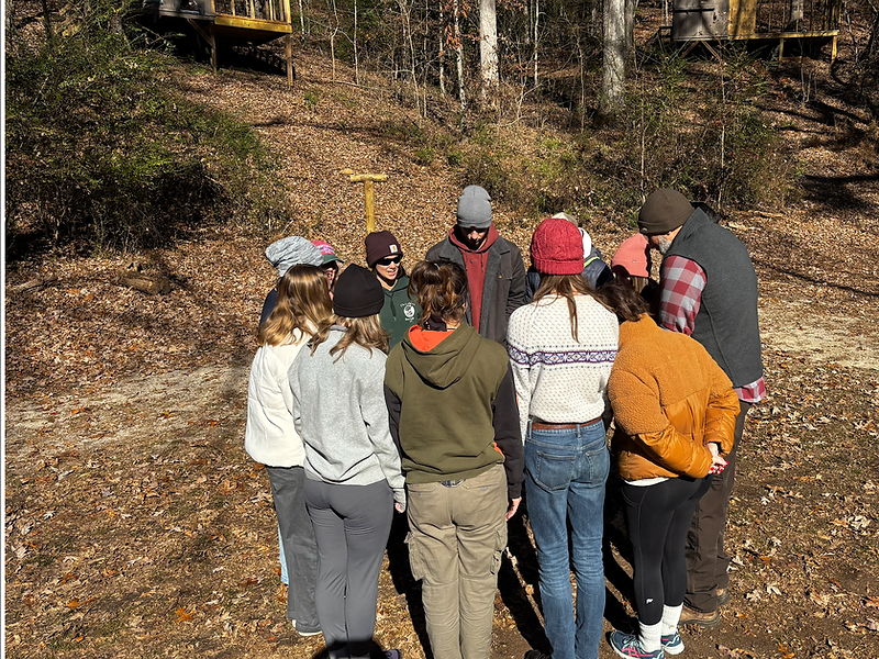 Team gathered in a circle during an on-site challenge