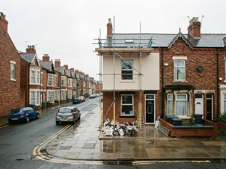 Red-brick terraced houses on a Sunderland street, one with newly rendered exterior walls