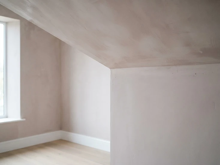 Smooth freshly plastered ceiling in an empty room lit by daylight