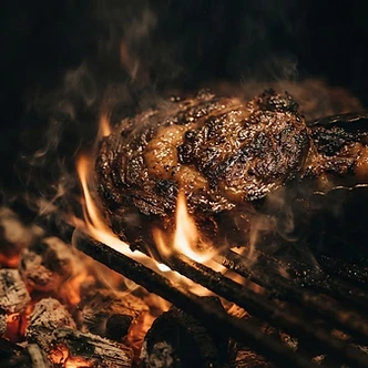 Ribeye searing over charcoal flames