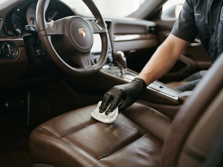 Detailer cleaning a leather car seat