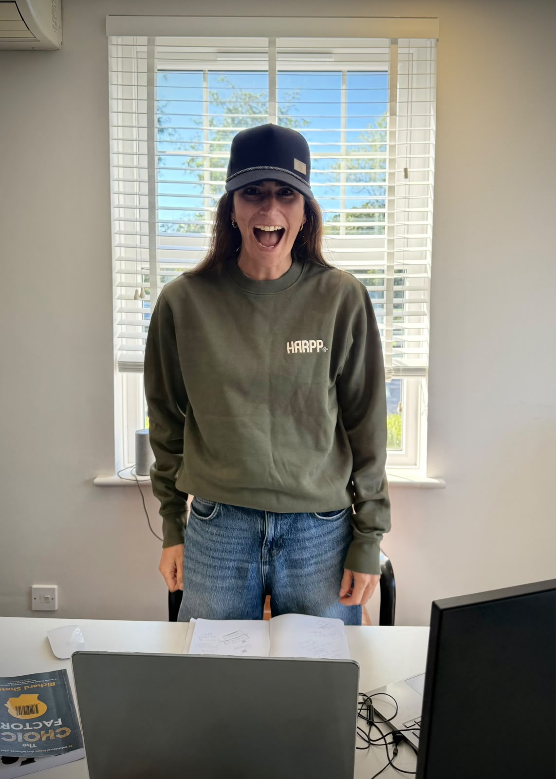 A member of the team at the studio desk, wearing a HARPP sweatshirt