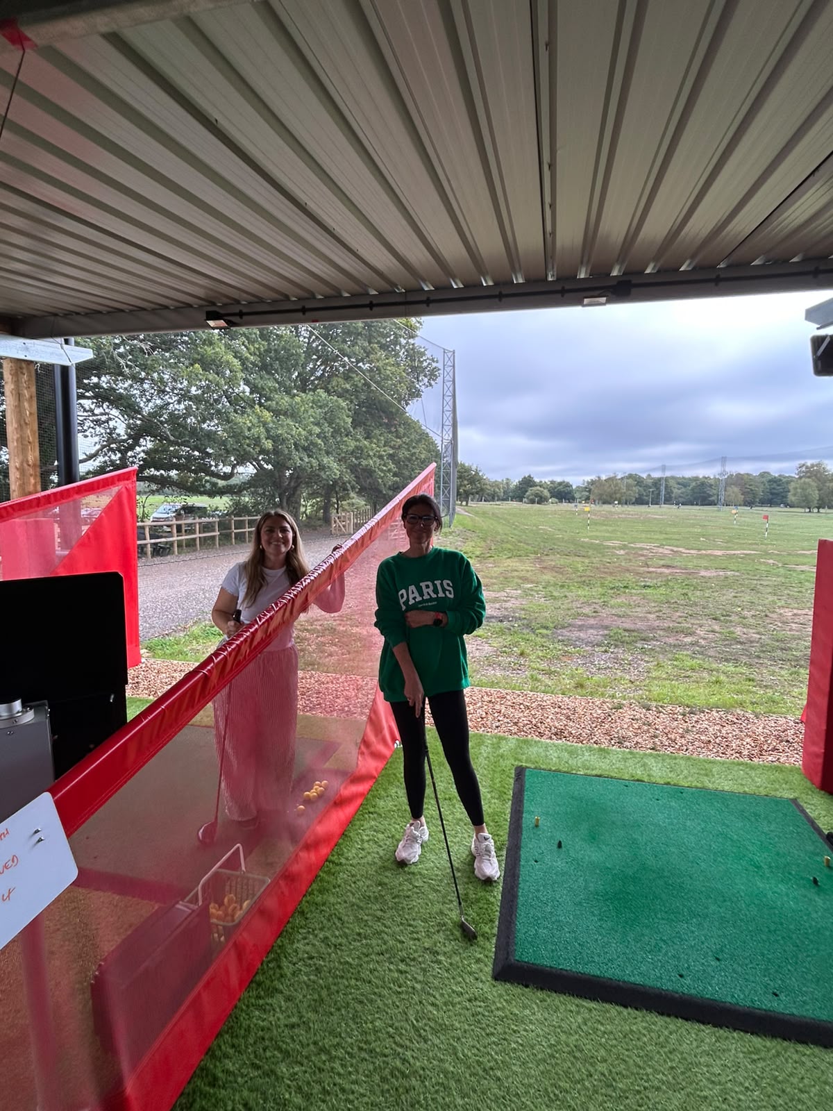 Two of the team at the driving range, mid-swing