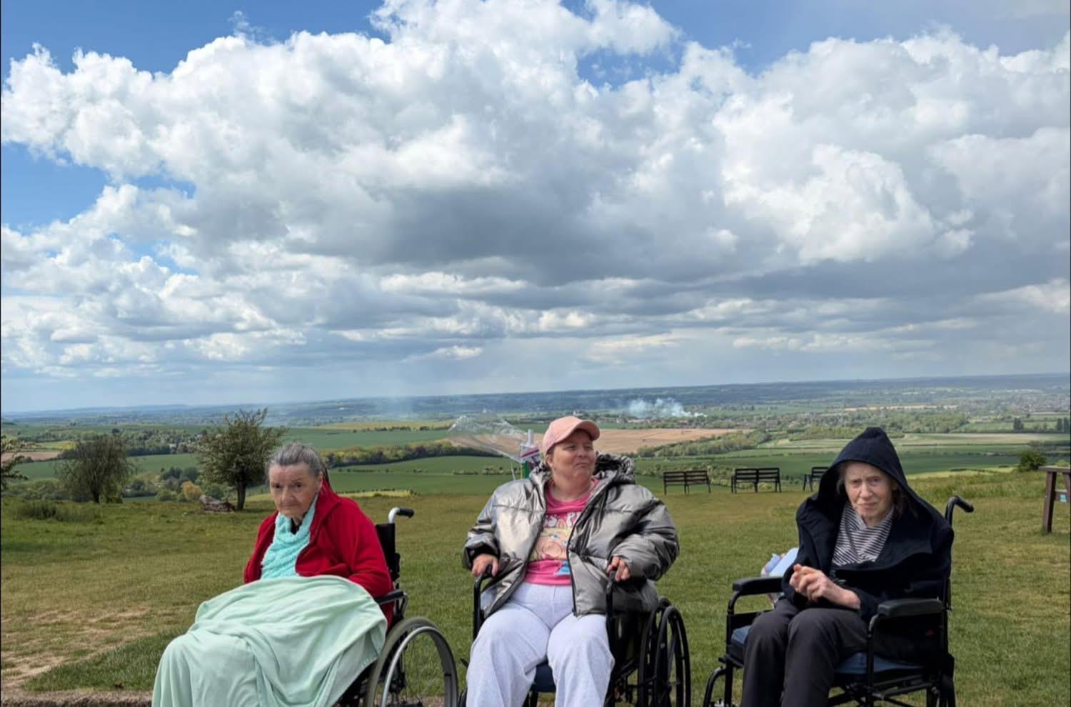 Travellers in wheelchairs taking in the view from a hilltop