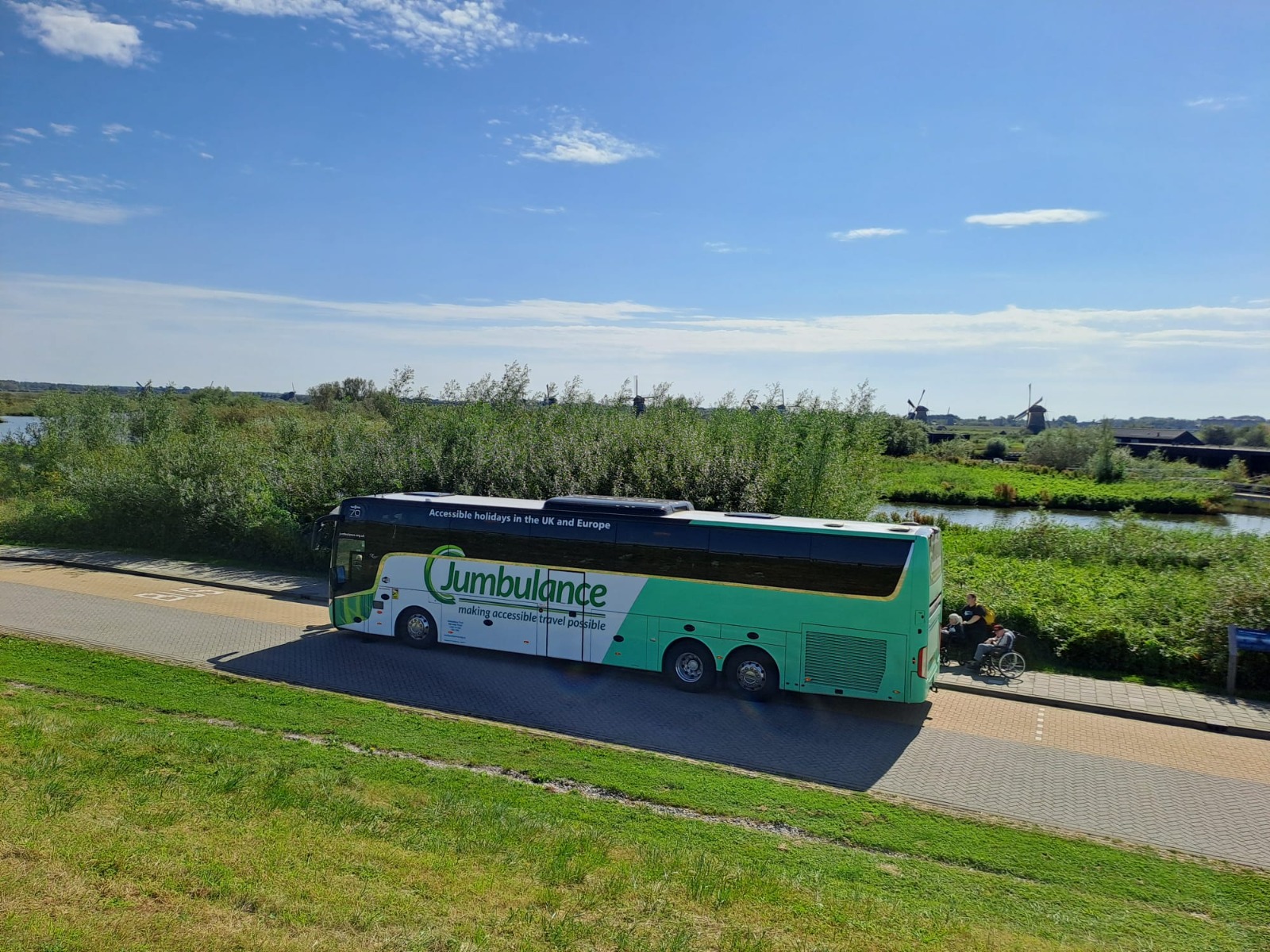 The Jumbulance coach parked in a scenic location with windmills in the distance