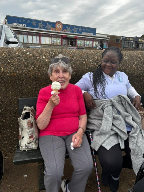 Two travellers enjoying ice cream by the sea