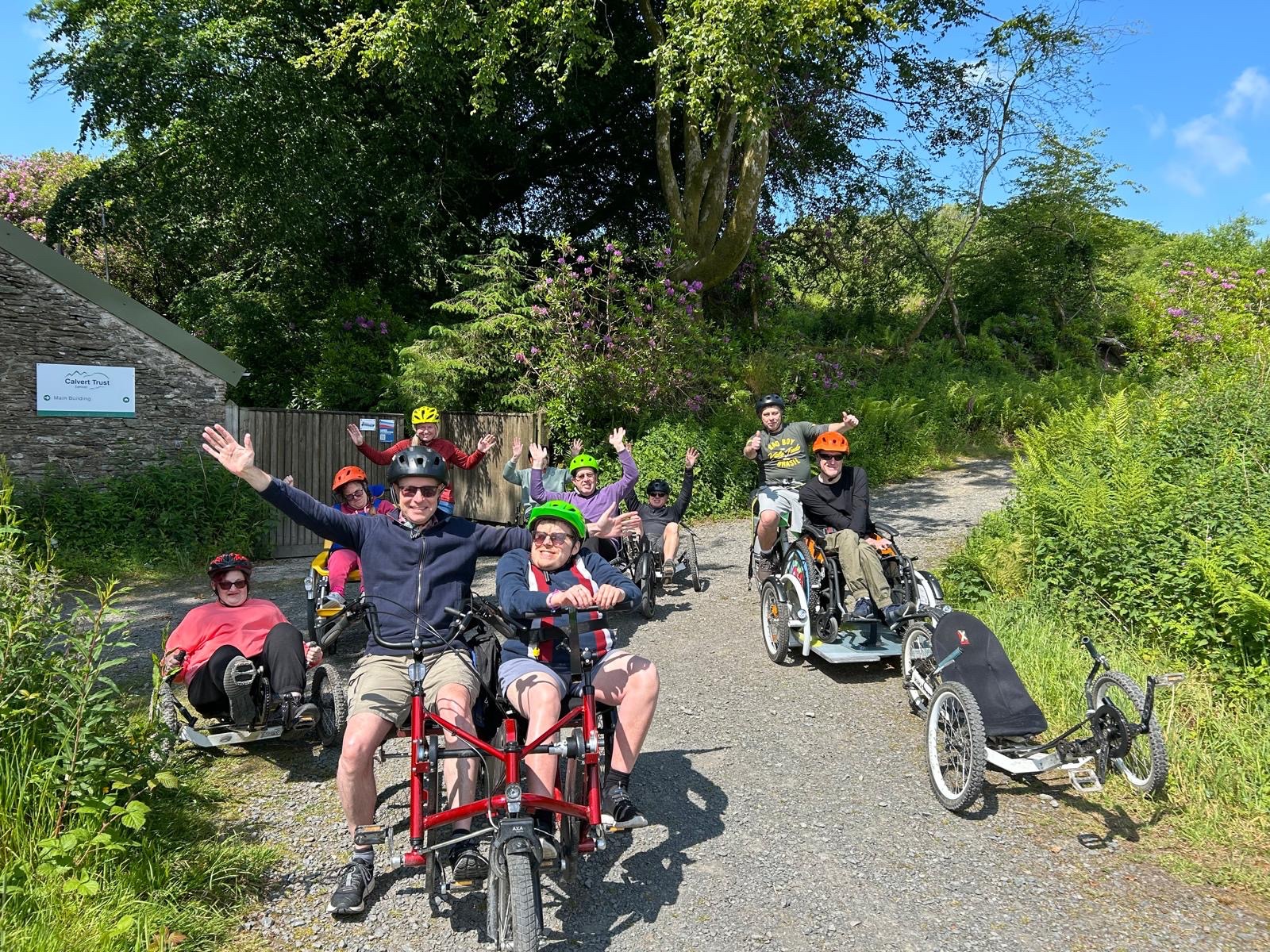 A group of riders on adaptive cycles enjoying an outdoor trail together