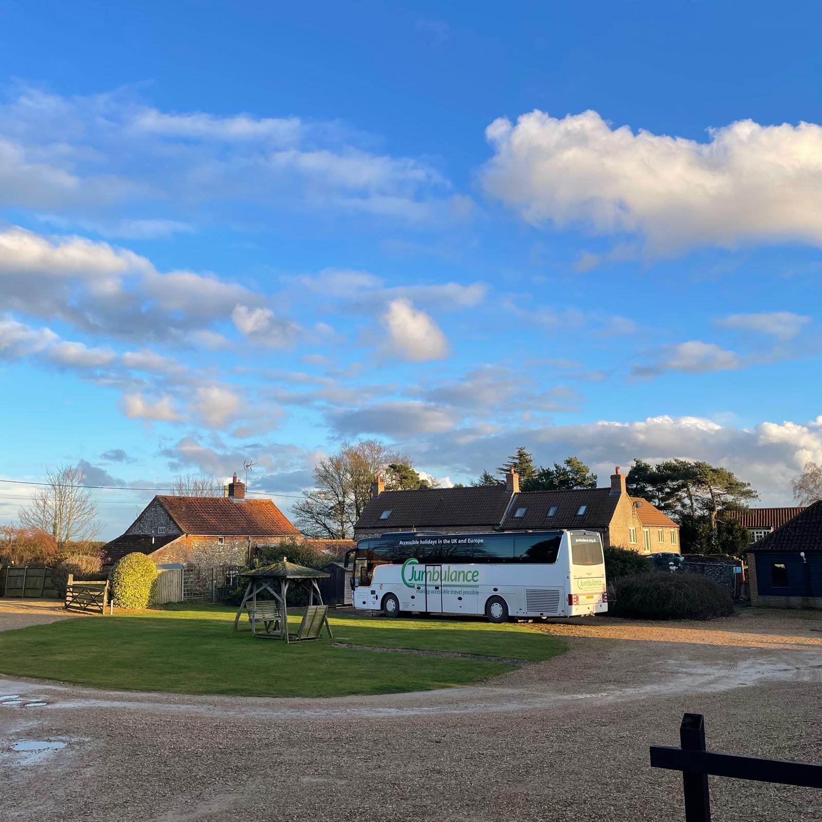 The Jumbulance coach parked in a rural courtyard beside stone buildings