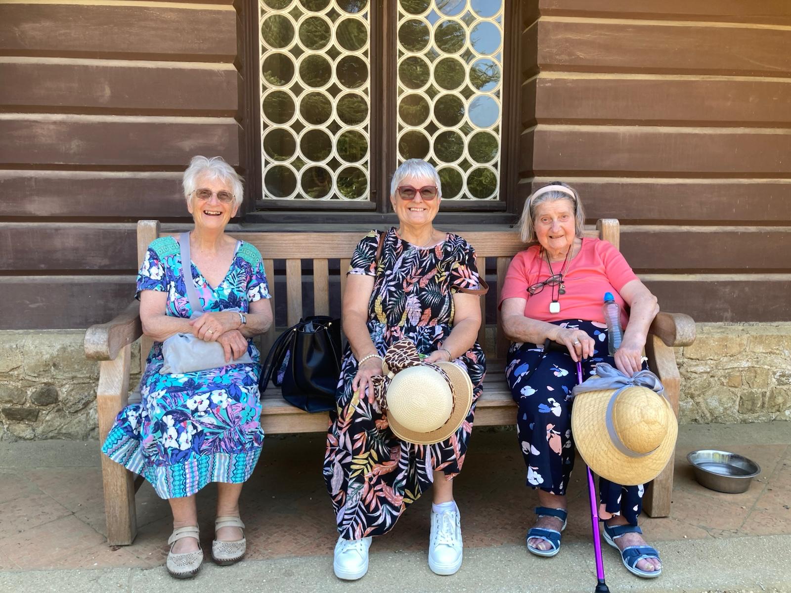 Three travellers resting on a park bench