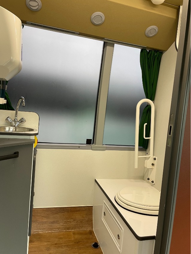 The accessible toilet on board a Jumbulance, with grab rail and basin.