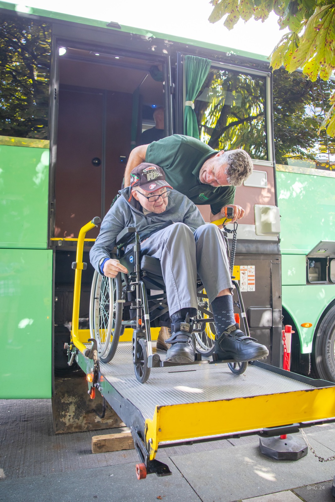 A traveller in a wheelchair being assisted onto the Jumbulance via the vehicle lift
