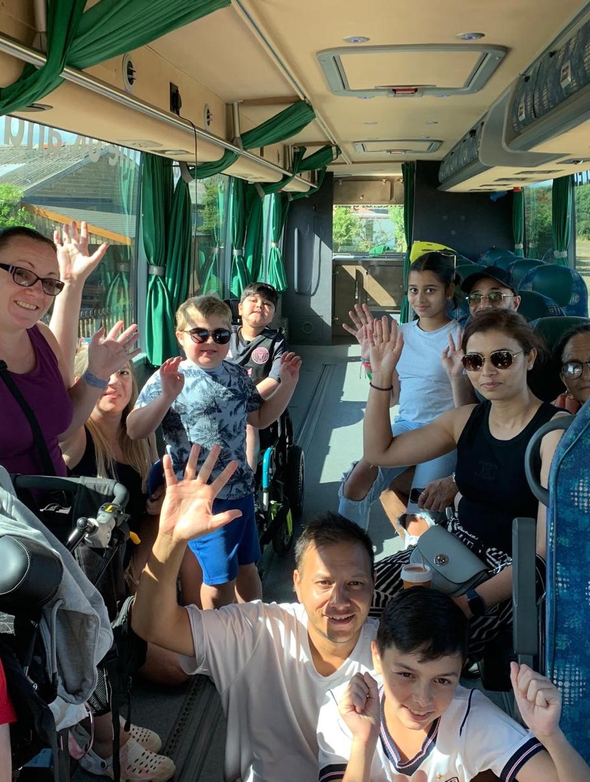 Passengers waving from inside the Jumbulance coach