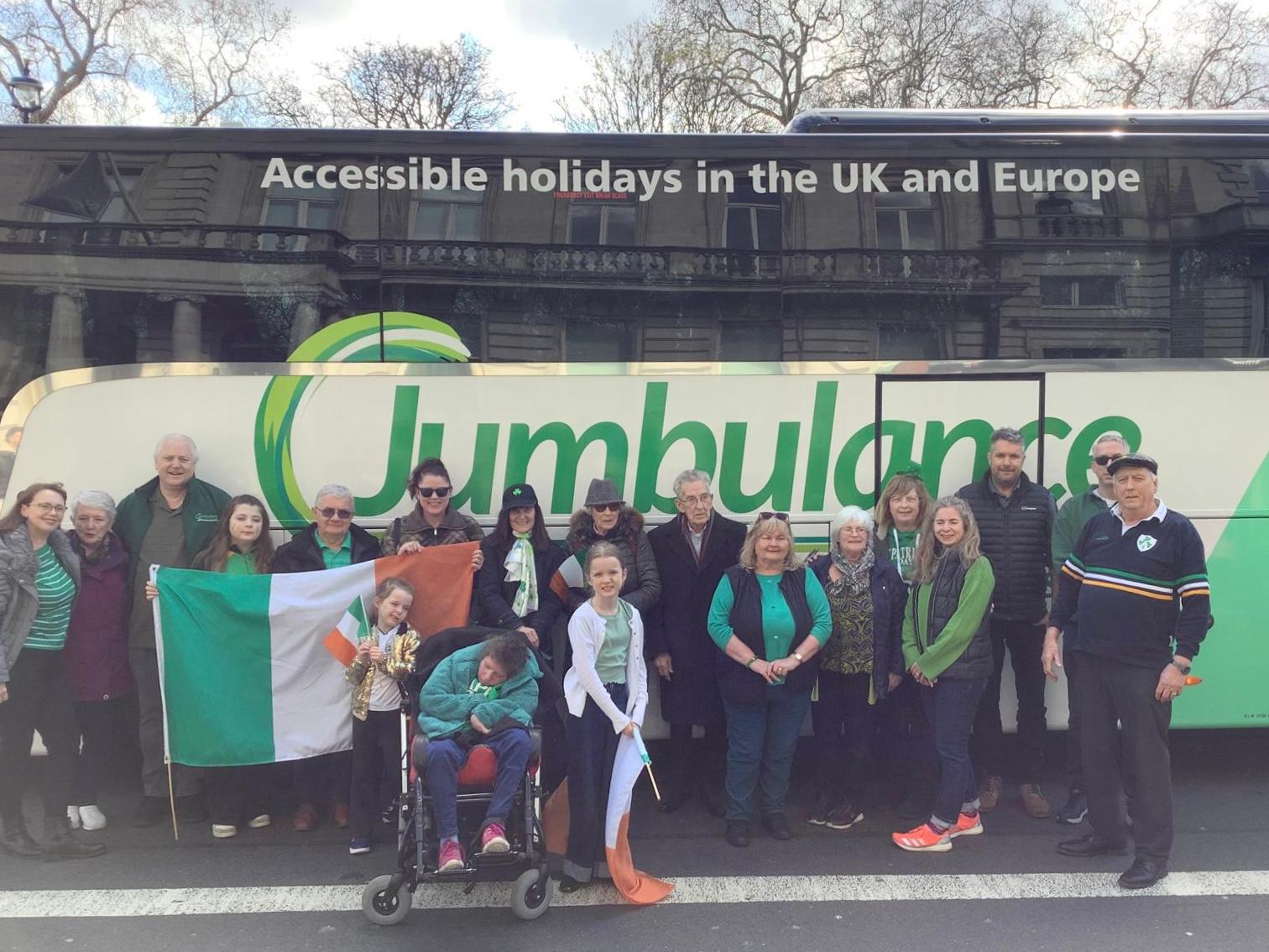 A group of Jumbulance travellers posing together in front of the coach before setting off
