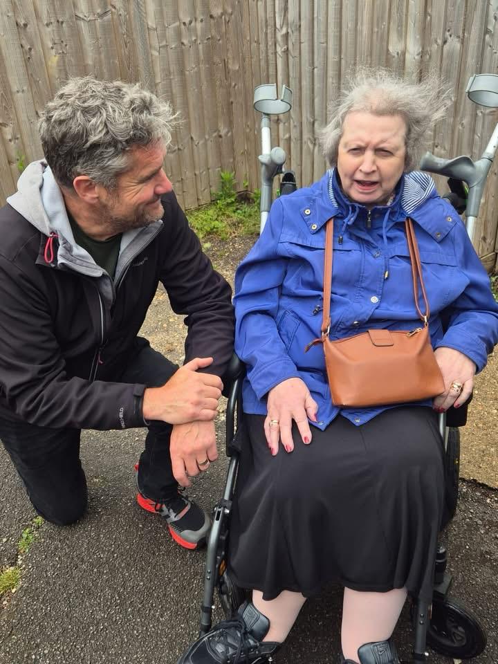 A traveller in her wheelchair with a volunteer