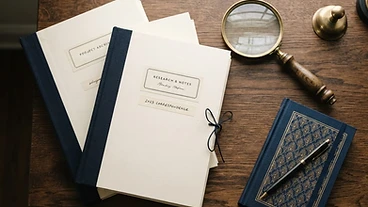 Editorial still life of labeled folders and a brass magnifier on a dark desk