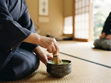 Japanese tea ceremony, hands whisking matcha on a tatami mat