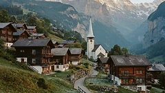 Calm Swiss alpine village with orderly houses and a church spire