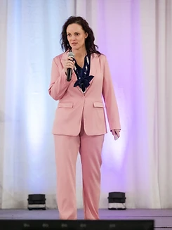 Kirstin Purcell on stage holding a microphone
