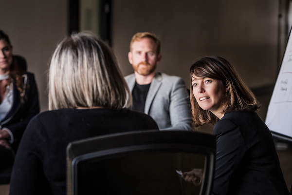 A coach facilitating a group coaching discussion with participants