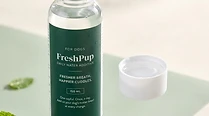 Close-up of the FreshPup bottle with the cap unscrewed, showing the measured dose