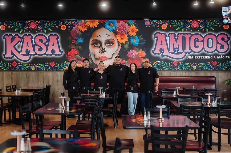 The Kasa Amigos team in front of the Día de los Muertos mural