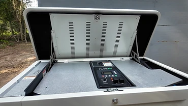 Open Kenerator unit showing the control panel, power switch and fuel and start toggles inside the lid