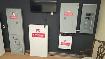 Kenerator transfer switch, control enclosures and monitoring screen installed on an interior charcoal wall