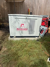 Kenerator standby generator installed against a wooden fence on a sunny day