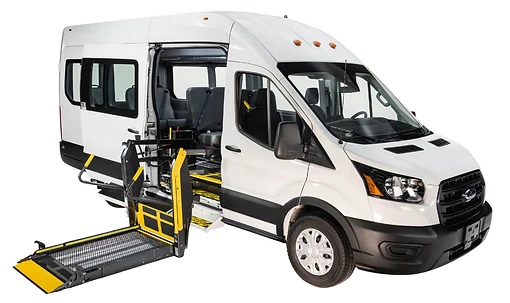 White commercial van with side-entry wheelchair lift deployed and a wheelchair on the platform
