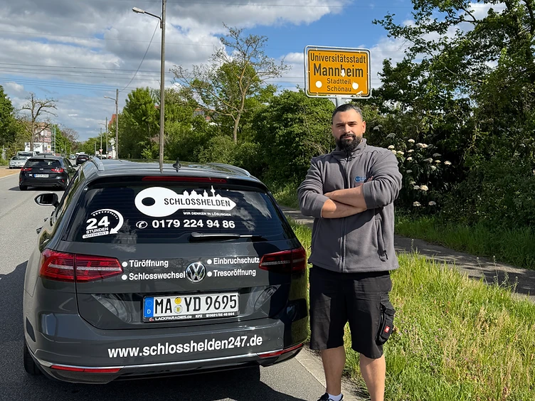 Dawid Akbarizadeh, Inhaber von Schlosshelden247, neben seinem mit Firmenlogo, Telefonnummer 0179 2249486 und Website www.schlosshelden247.de beschrifteten Firmenfahrzeug in Mannheim-Schönau