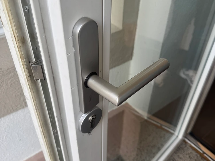 Profilzylinder mit Schlüsselloch und Türbeschlag bei einem Schlosswechsel