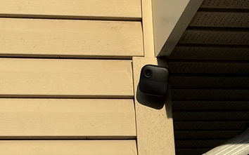 Battery-powered wireless security camera installed on residential exterior