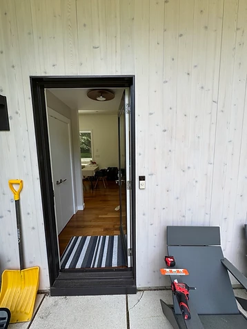 Video doorbell installation beside a black-framed glass entry door